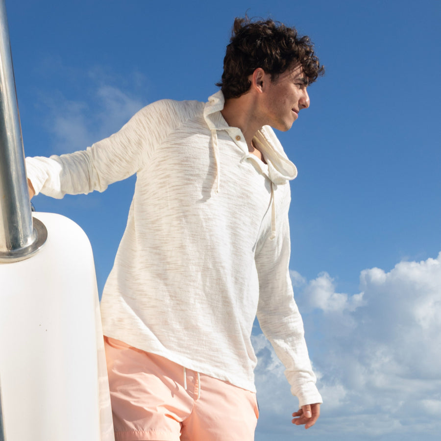 Man in a Pearle BreezeWeight Pullover Hoodie on a boat deck under a blue sky