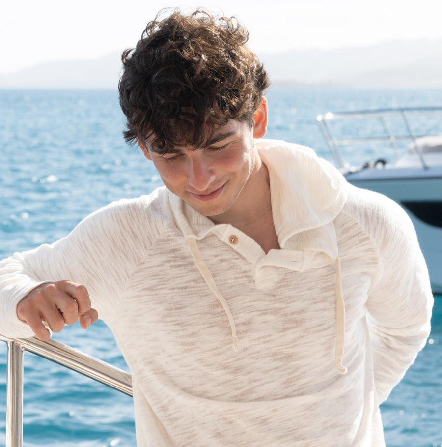 Man in a Pearle BreezeWeight Pullover Hoodie leaning on a boat railing